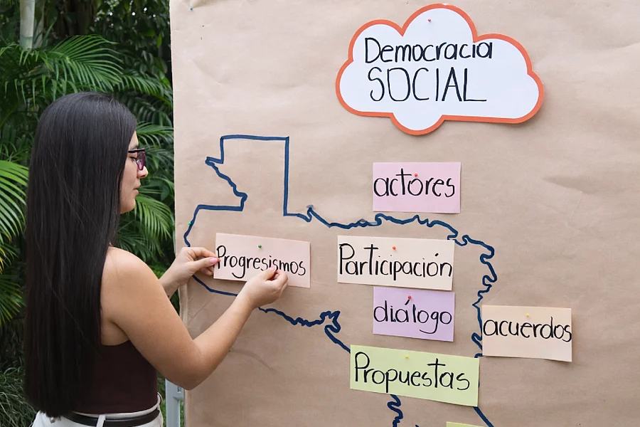 Mujer joven haciendo metaplan con conceptos de democracia social.